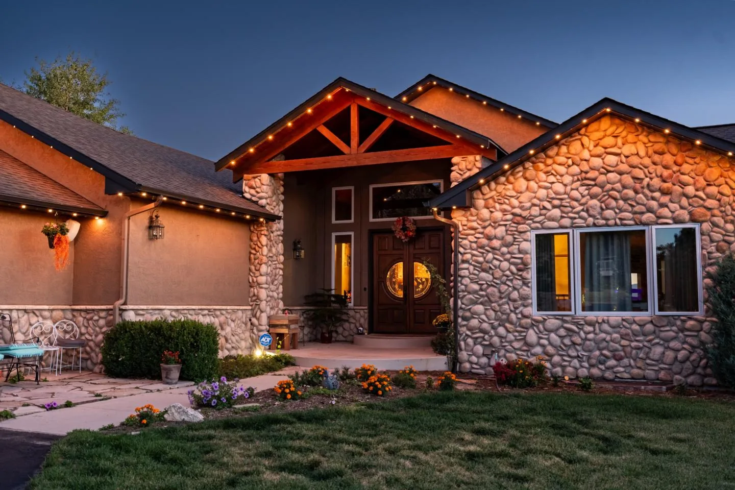 Twin Cities home with permanent roofline lighting glowing warm white on a cold winter night