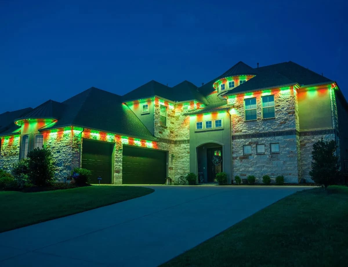 Permanent Christmas lights in red and green on a Minnesota home's roofline